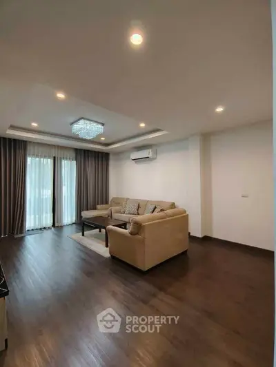 Spacious living room with elegant lighting and cozy seating area.