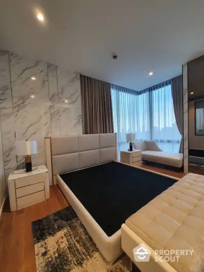 Luxurious bedroom with marble wall accent, plush king-sized bed, and elegant drapery, offering a serene urban retreat.