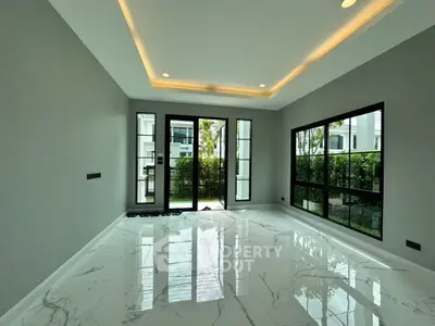 Spacious modern living room with large windows and marble flooring
