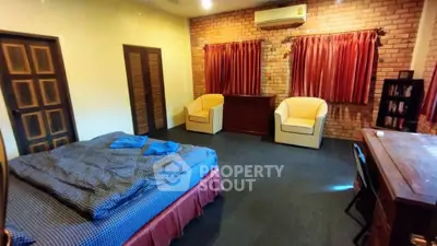 Spacious bedroom with cozy seating and rustic brick wall design