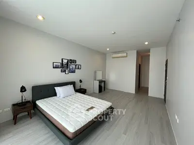 Spacious modern bedroom with minimalist decor and ample natural light