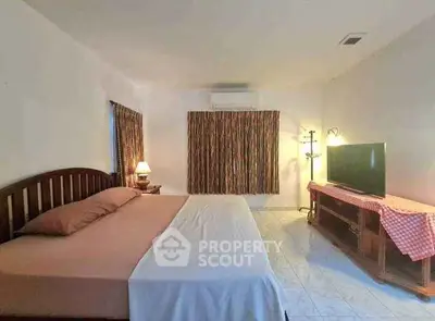 Spacious bedroom with large bed and TV, ideal for relaxation.