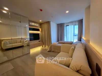Modern living room with mirrored closet and cozy seating area, featuring natural light and elegant decor.