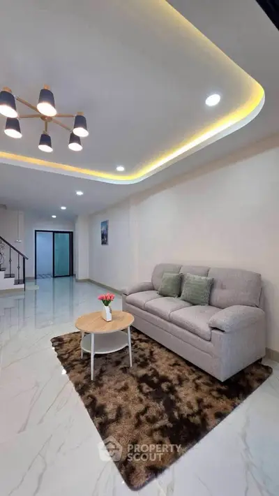 Spacious modern living room with elegant lighting and cozy seating area.