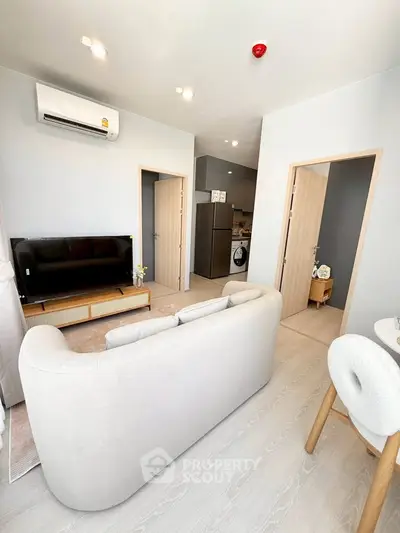 Modern living room with cozy sofa and sleek TV setup in a stylish apartment.