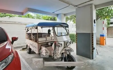 Unique parking area featuring a tuk-tuk in a modern residential building.