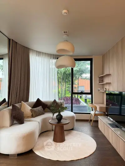 Elegant living room with modern furniture and large windows offering garden view