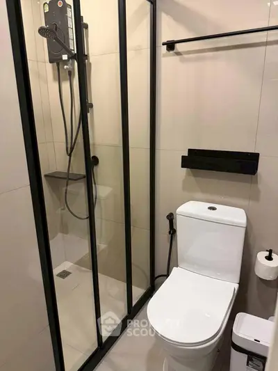 Modern bathroom with glass shower enclosure and sleek fixtures.