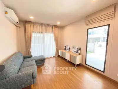 Spacious living room with modern decor and large window for natural light.