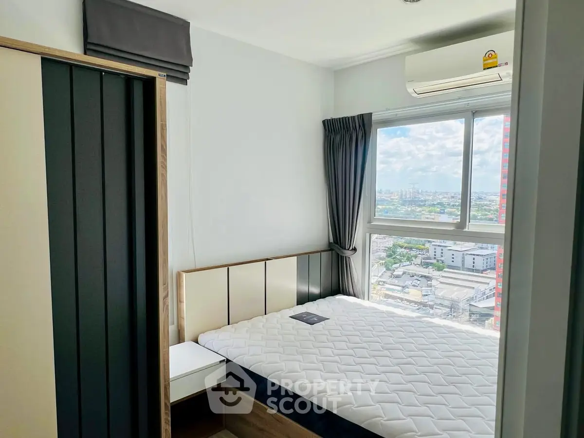 Modern bedroom with city view, featuring a comfortable bed and air conditioning, perfect for urban living.