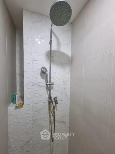 Modern shower area with sleek fixtures and textured wall tiles in a contemporary bathroom.