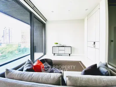 Modern living room with large windows and balcony view in luxury apartment.