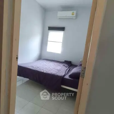 Cozy bedroom with air conditioning and natural light, perfect for relaxation.