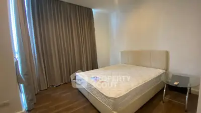 Spacious bedroom with elegant curtains and a comfortable bed in a modern apartment.
