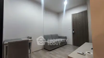 Modern minimalist living room with gray sofa and dining table, ideal for urban living.