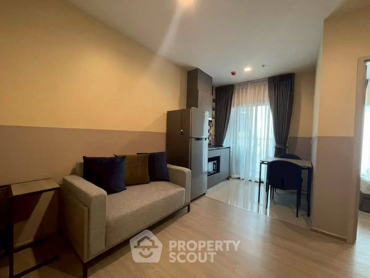 Modern living room with cozy sofa and kitchenette in open layout apartment