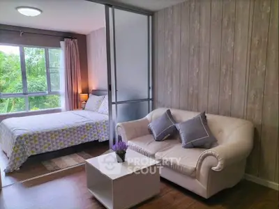 Cozy bedroom with stylish decor and natural light, featuring a comfortable sofa and modern design.