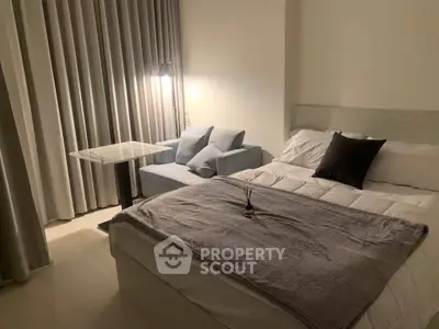 Cozy bedroom with modern decor, featuring a comfortable bed, stylish sofa, and elegant lighting.