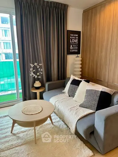 Cozy living room with modern decor, featuring a plush sofa, stylish coffee table, and large window with balcony view.