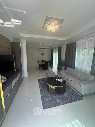 Luxurious living room with modern decor and elegant chandelier, perfect for stylish living.