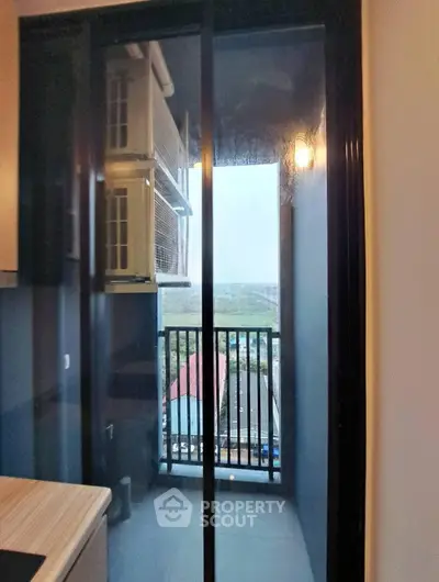 Modern apartment balcony with sliding glass door and city view