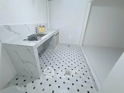 Modern minimalist kitchen with marble countertops and geometric floor tiles