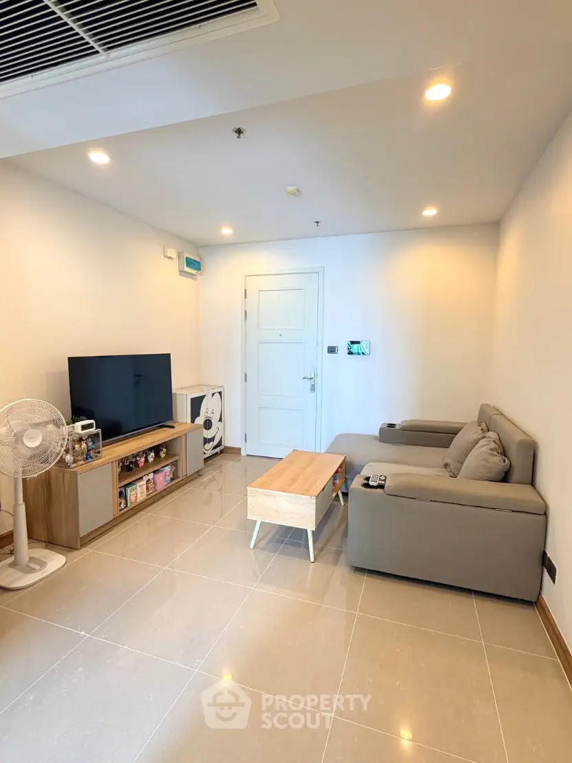 Modern living room with sleek furniture and large TV, perfect for relaxation and entertainment.
