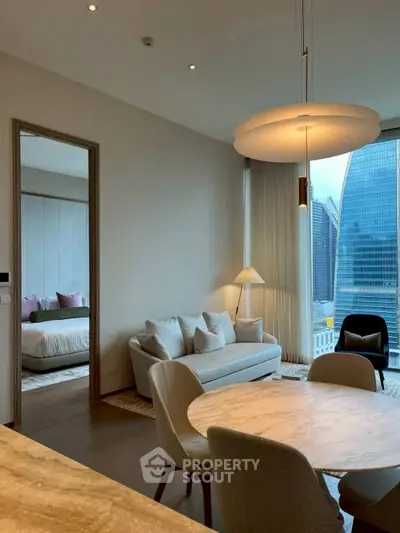 Modern living room with city view, elegant furniture, and adjacent bedroom.