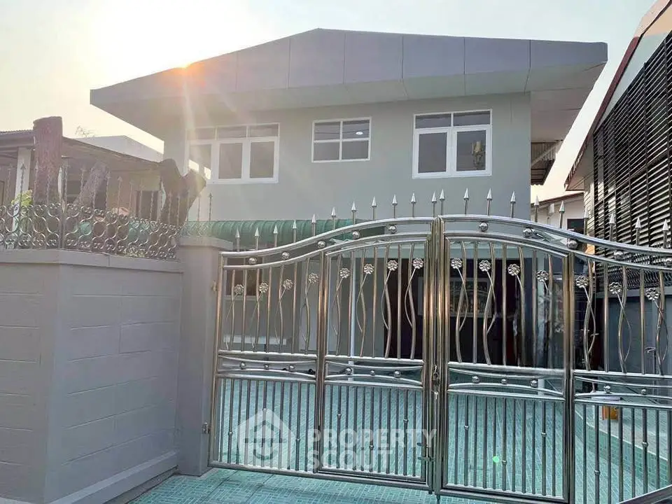 Modern two-story house with sleek metal gate and contemporary design