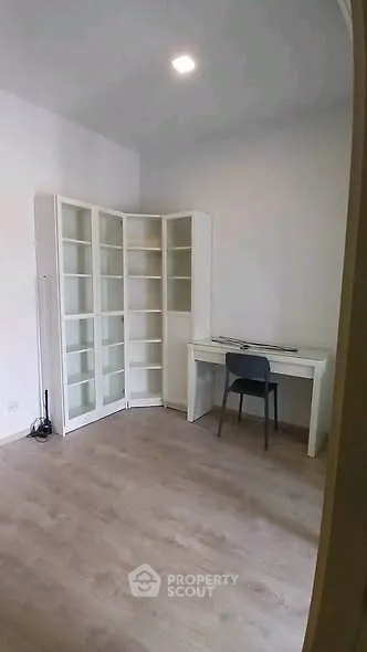 Spacious study room with modern desk and shelving, perfect for productivity.