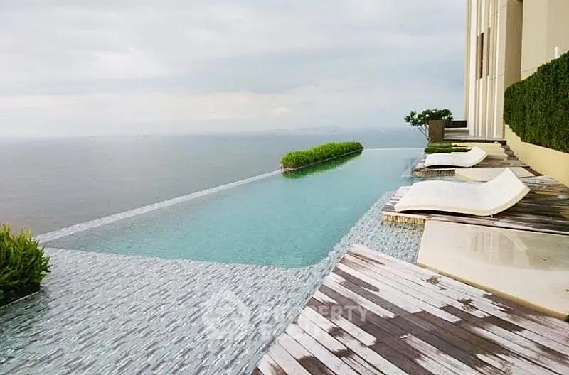 Luxurious infinity pool with stunning ocean view and modern lounge chairs.