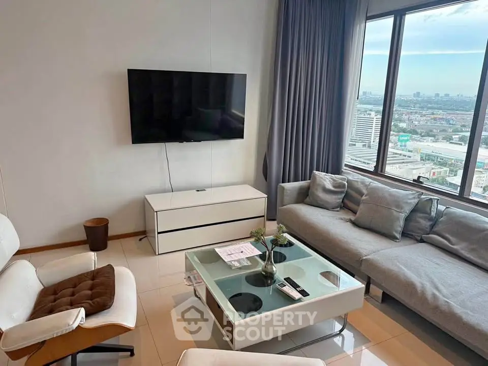 Modern living room with city view, sleek furniture, and large windows for natural light.