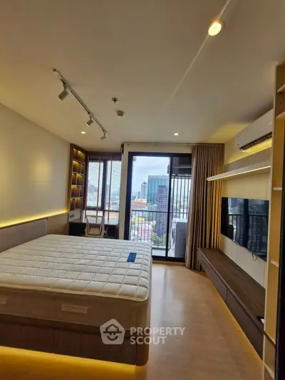Modern bedroom with city view, featuring a large bed, built-in shelves, and a wall-mounted TV.