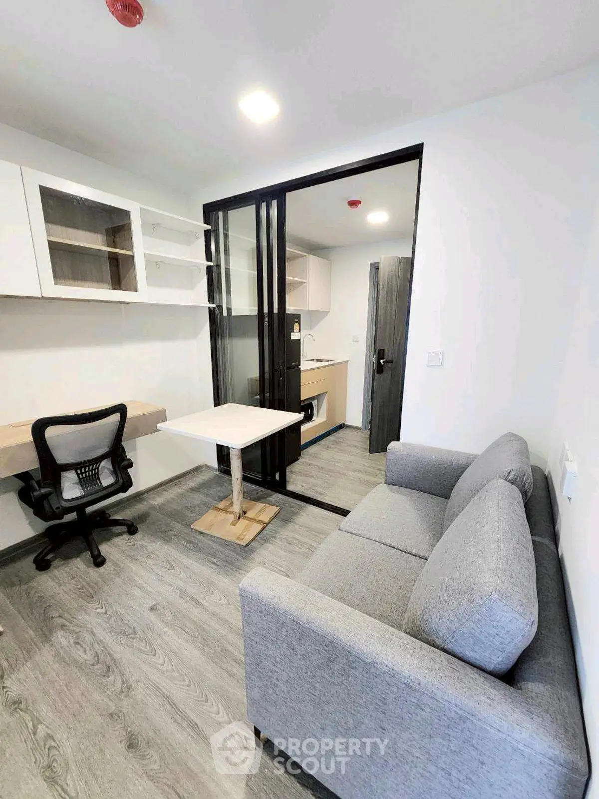 Modern studio apartment with sleek furniture and compact kitchen area, perfect for urban living.