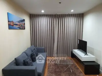 Modern living room with cozy sofa, glass coffee table, and flat-screen TV, perfect for relaxation.