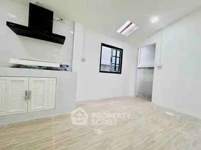 Modern kitchen with sleek white cabinets and stylish range hood in a bright, minimalist design.