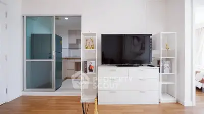 Modern living room with sleek TV stand and open kitchen layout