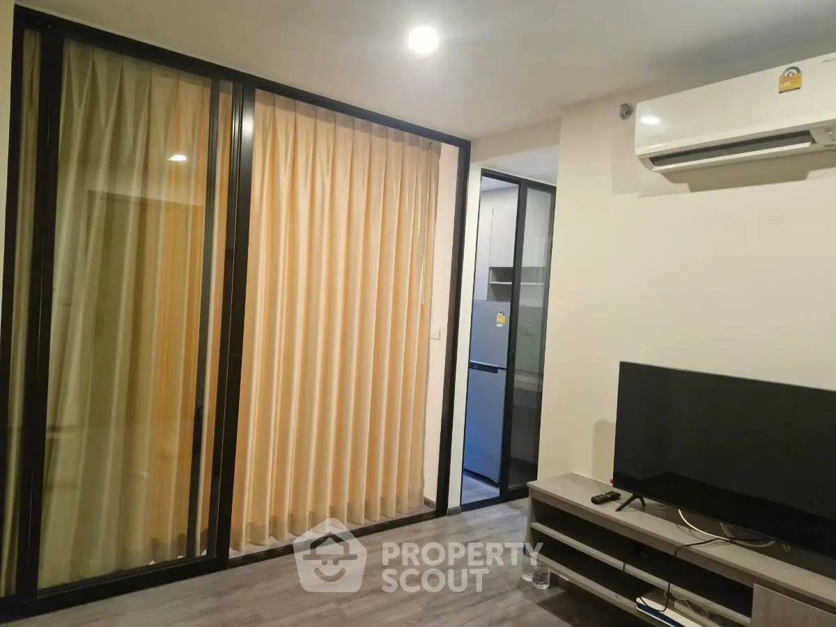Modern living room with sliding glass doors and air conditioning in a stylish apartment.