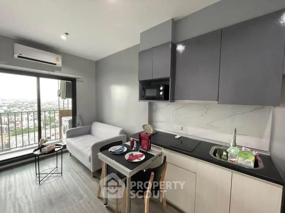 Modern compact living room with kitchenette and balcony view
