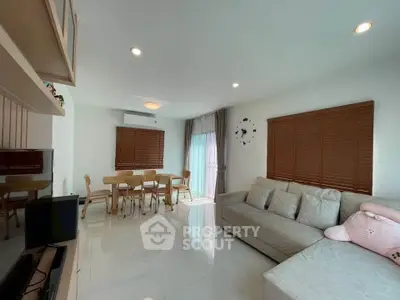 Spacious modern living room with cozy sofa and dining area, perfect for family gatherings.
