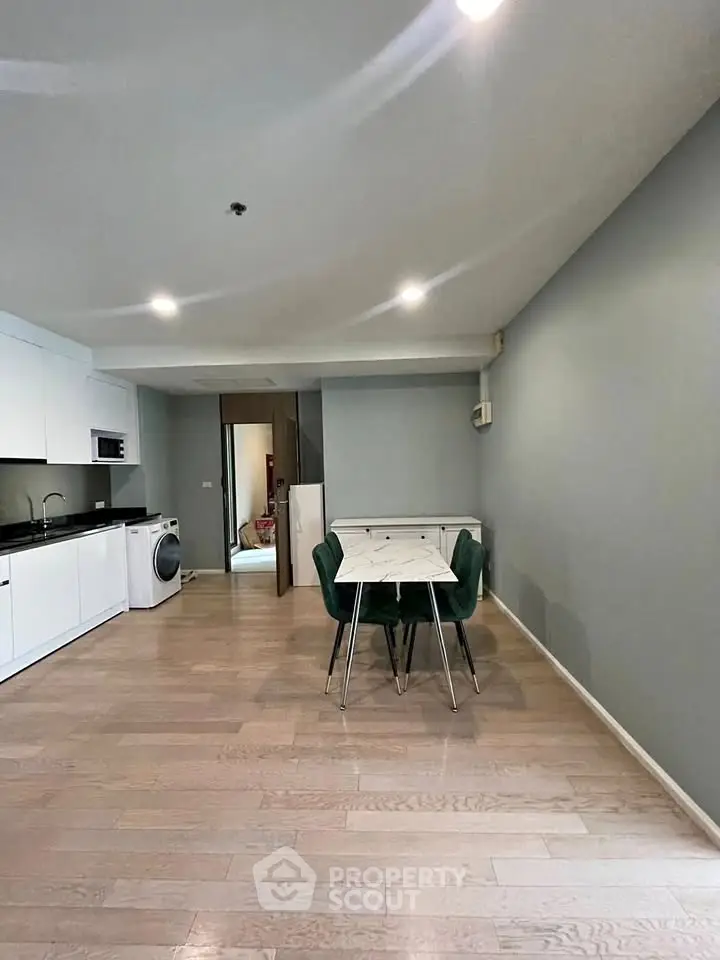 Modern open-plan kitchen and dining area with sleek design and hardwood floors.