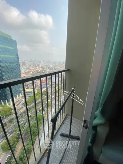 Stunning city view from a high-rise balcony with modern railing and urban skyline.