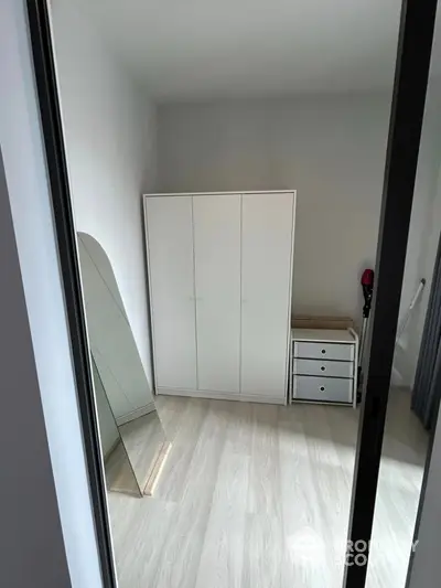 Modern minimalist bedroom with sleek wardrobe and stylish mirror