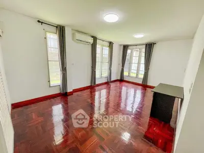 Spacious living room with polished wooden floors and large windows