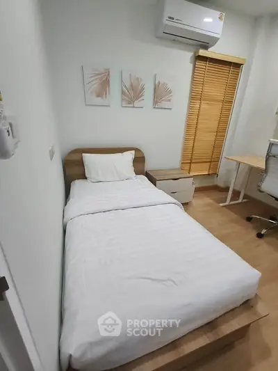 Cozy bedroom with single bed, air conditioning, and modern decor in a stylish apartment.