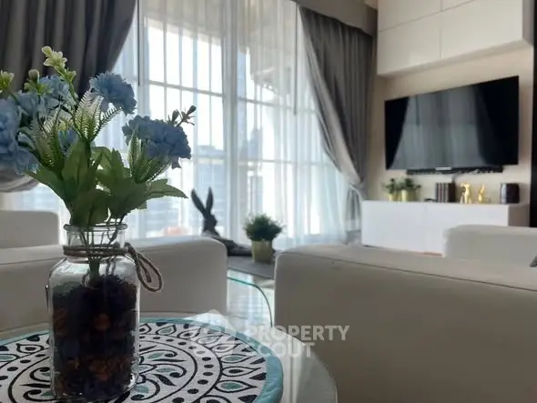 Luxurious living room with elegant decor and large windows offering stunning city views.