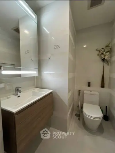 Modern bathroom with sleek fixtures and elegant design, featuring a stylish vanity and contemporary toilet.