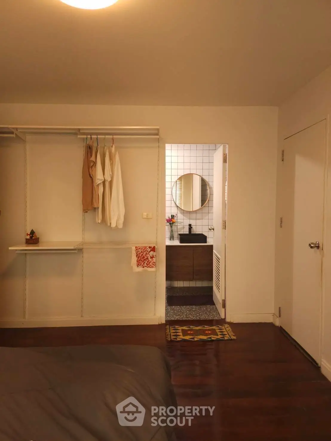 Cozy bedroom with open closet and view into modern bathroom