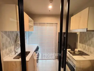 Modern kitchen with sleek cabinetry and built-in appliances in a compact layout.