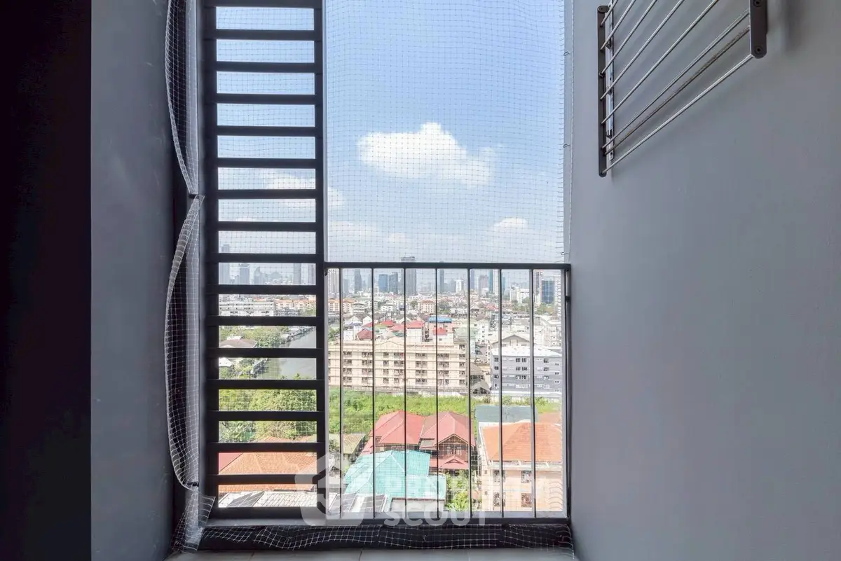 Stunning cityscape view from a modern apartment balcony with safety grill and netting.